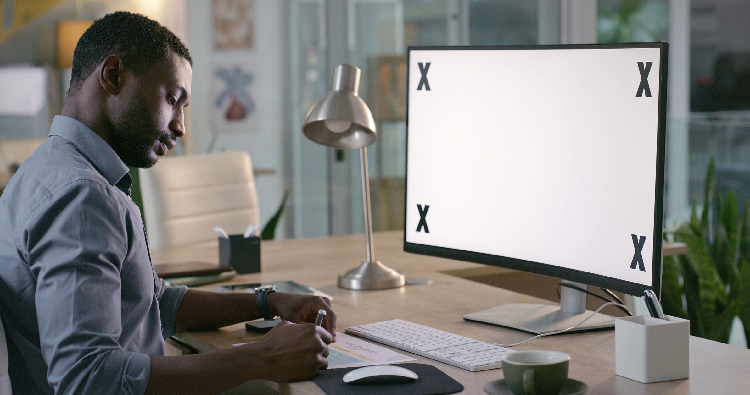 Security professional working at a desk with a laptop and notes