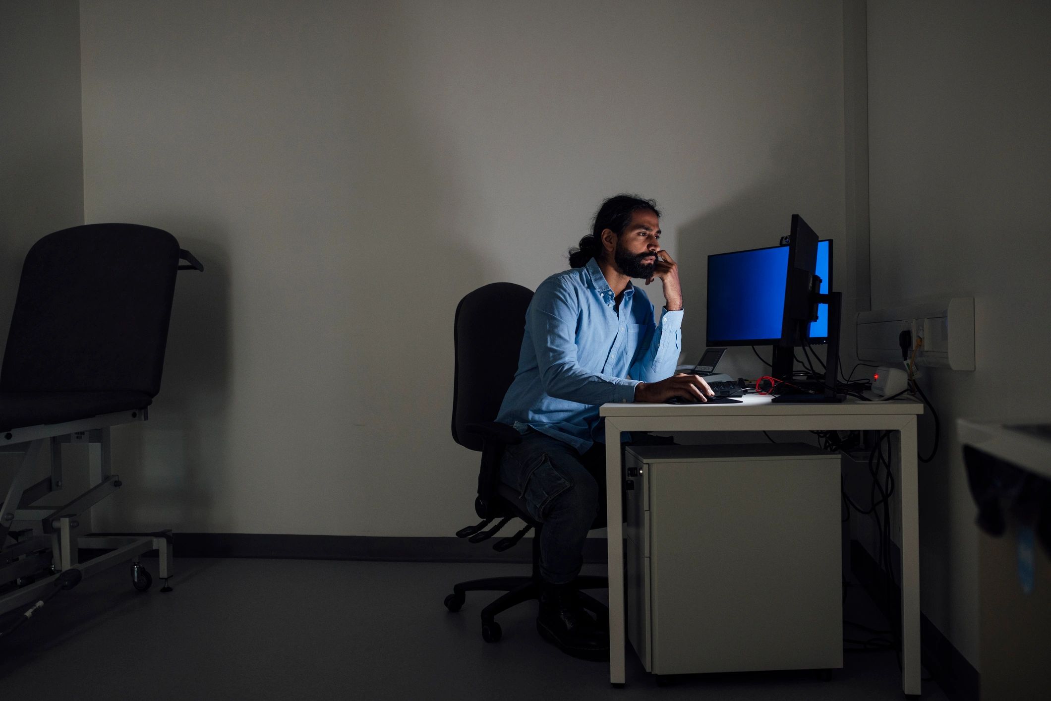 Security professional working at a laptop in a modern office setting.