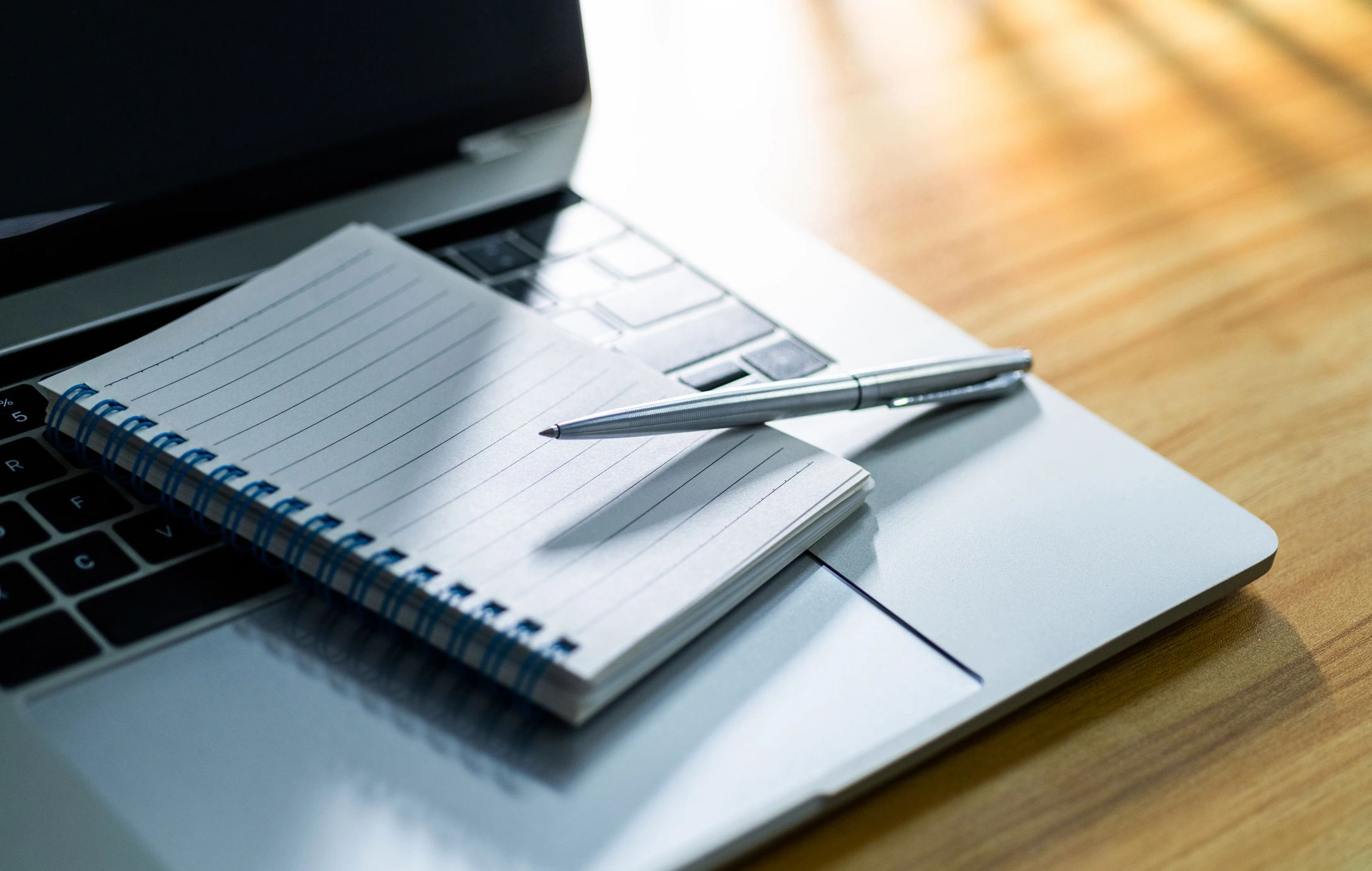 Notebook and laptop on desk for planning and note-taking